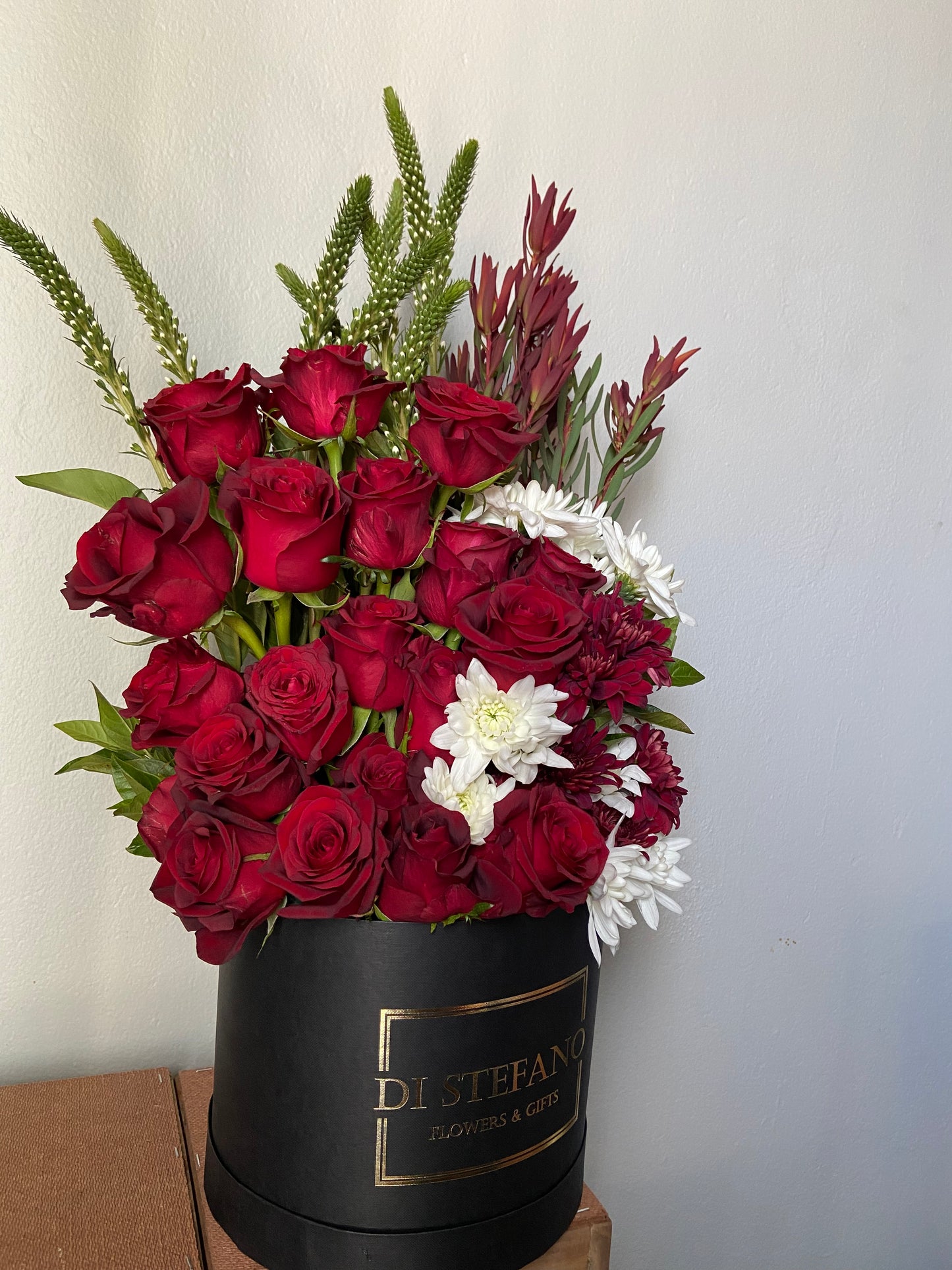 red rose floral arrangement in large hatbox