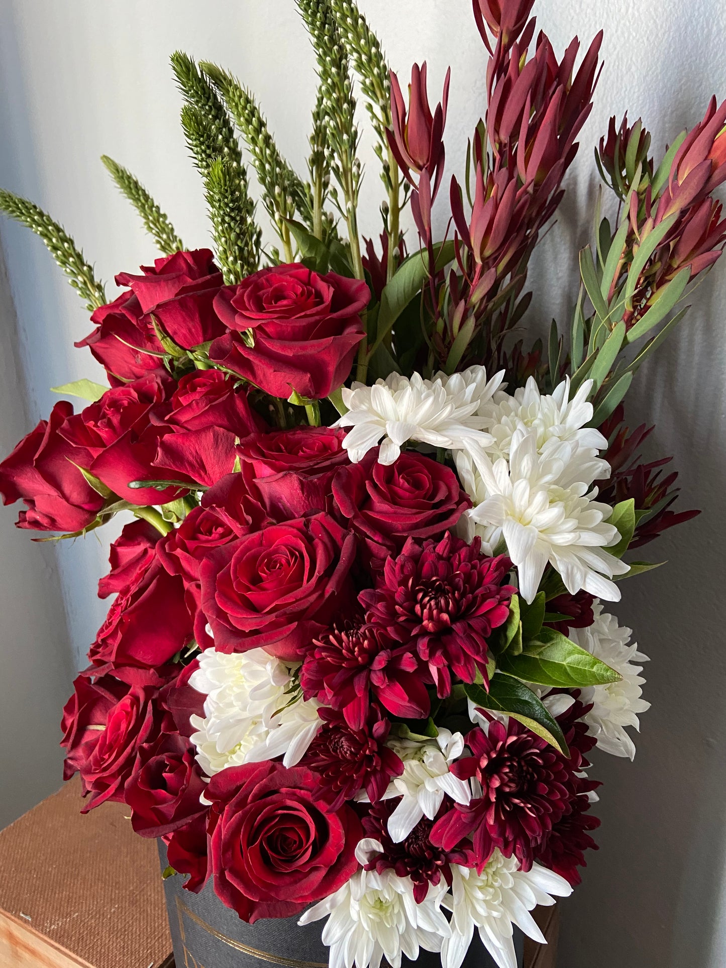 red rose floral arrangement in large hatbox