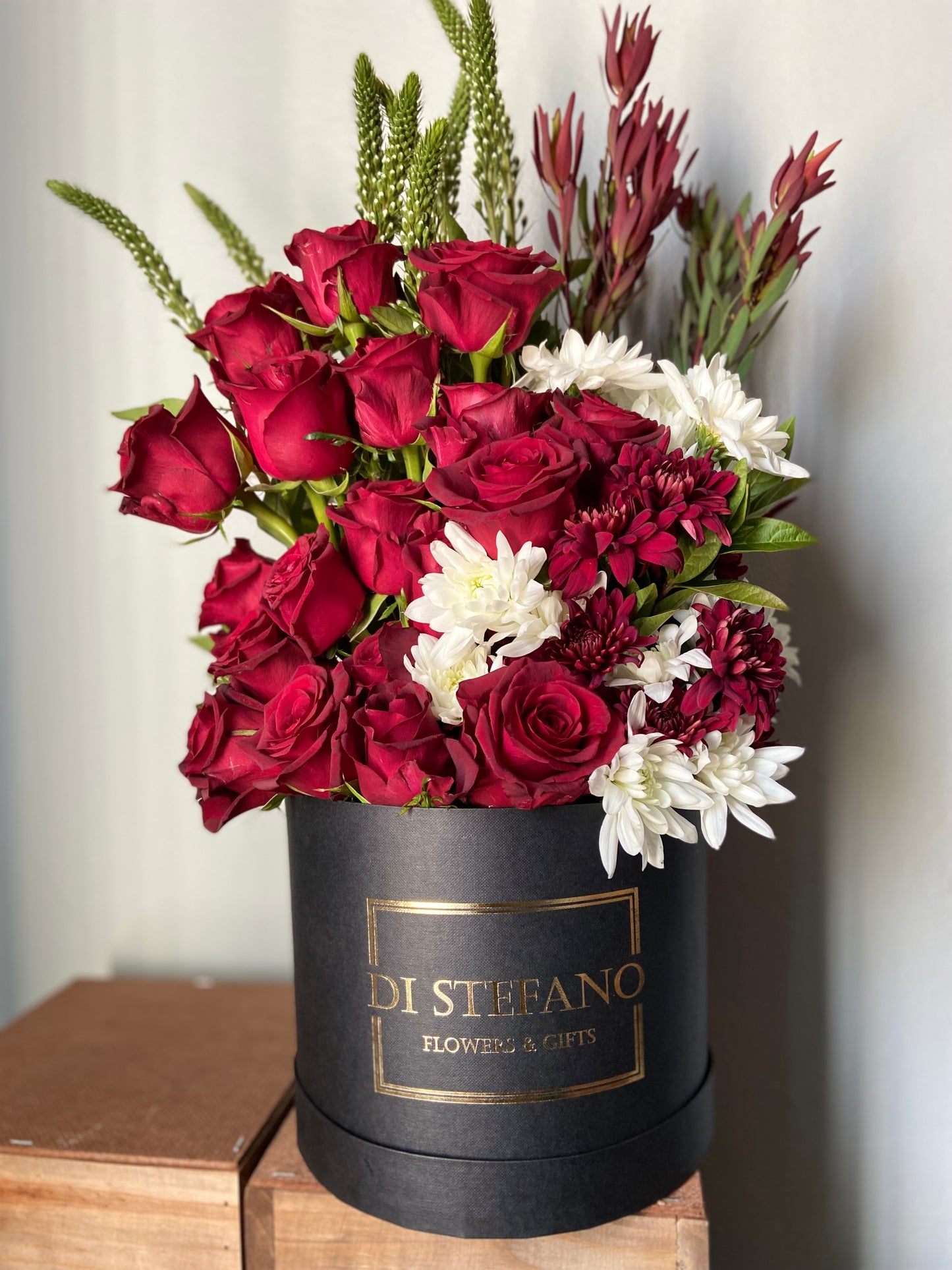 red rose floral arrangement in large hatbox